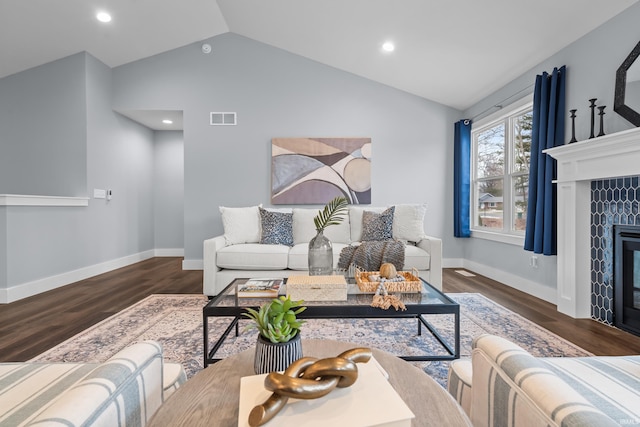 living area featuring vaulted ceiling, wood finished floors, a tile fireplace, and visible vents