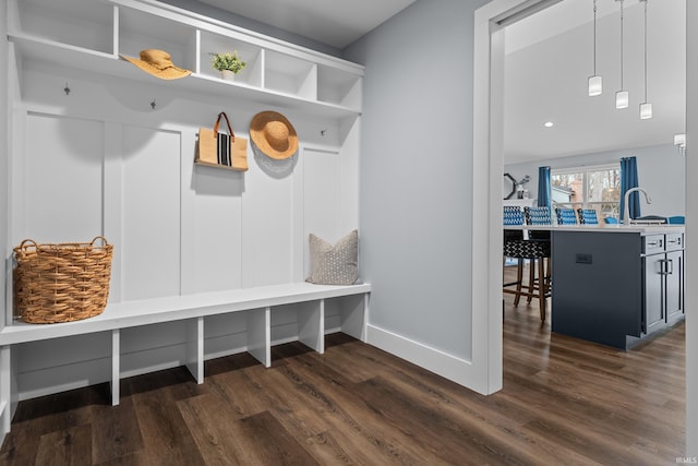 mudroom with a sink, baseboards, and dark wood-style flooring