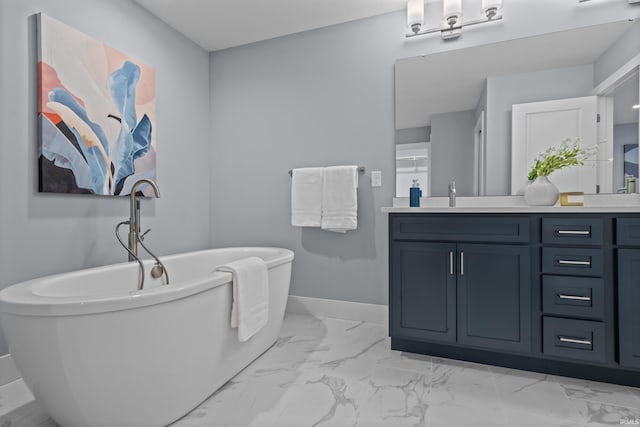 full bathroom with marble finish floor, baseboards, a soaking tub, and vanity