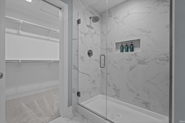 bathroom featuring marble finish floor, a spacious closet, and a stall shower