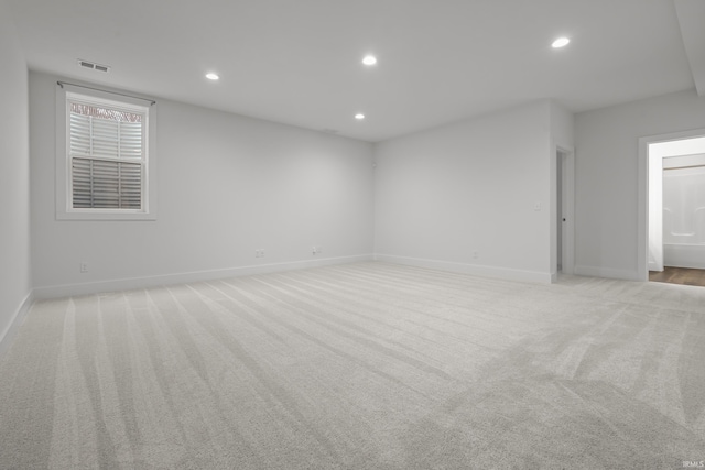 unfurnished room with baseboards, visible vents, light colored carpet, and recessed lighting