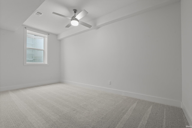 spare room with a ceiling fan, carpet, visible vents, and baseboards