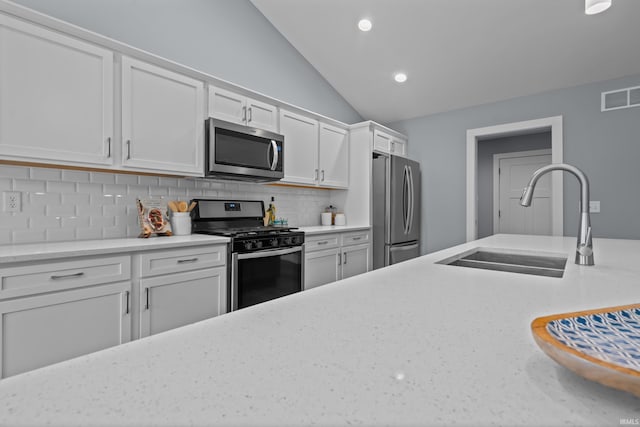 kitchen with stainless steel appliances, visible vents, backsplash, white cabinets, and a sink