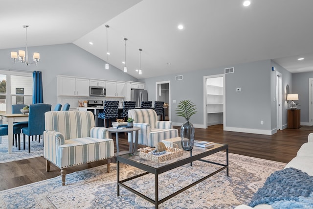 living area with high vaulted ceiling, dark wood-style flooring, visible vents, and a notable chandelier