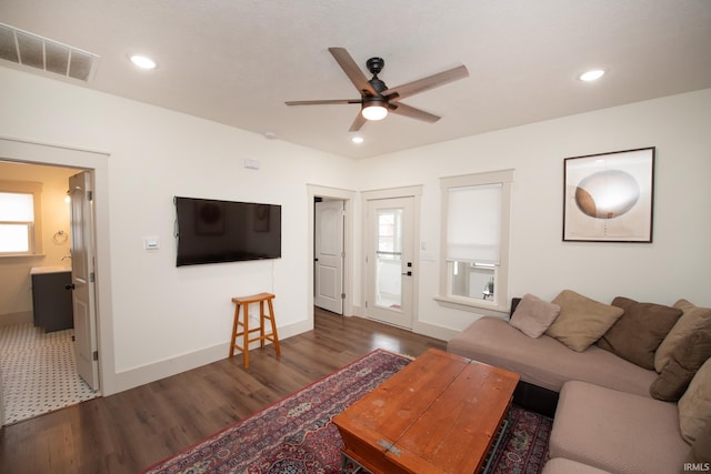 living area featuring baseboards, visible vents, wood finished floors, and recessed lighting