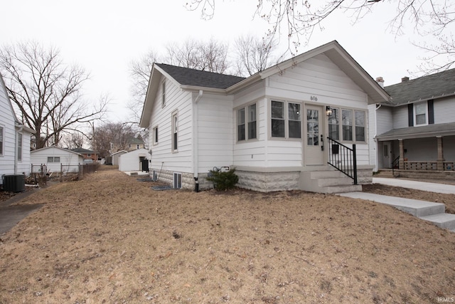 view of front of property with entry steps, roof with shingles, cooling unit, and fence