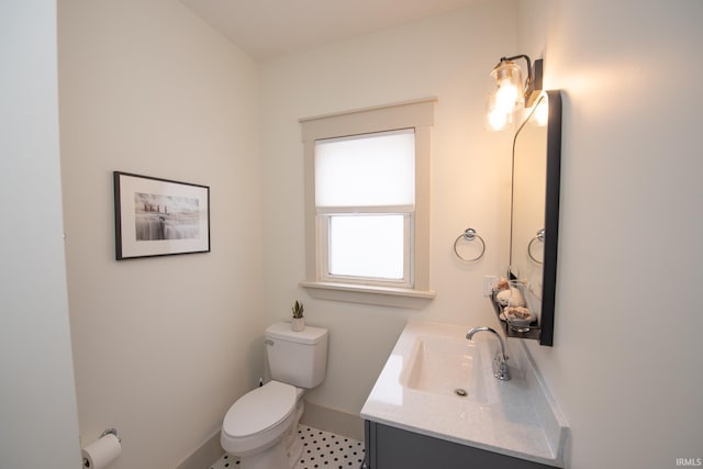 half bath featuring toilet, baseboards, and vanity