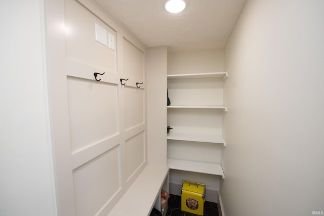 interior space featuring a textured ceiling and baseboards