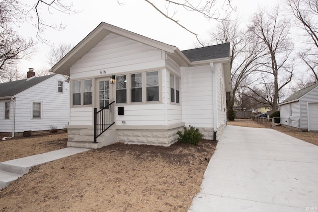 bungalow with entry steps and a shingled roof