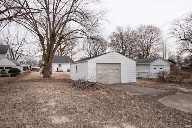 detached garage with fence and driveway