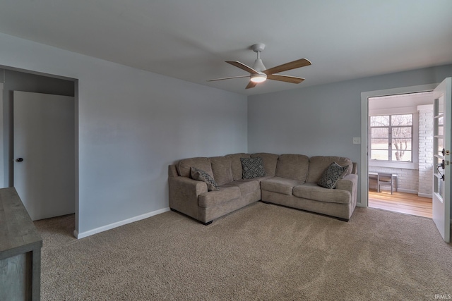 carpeted living room with ceiling fan and baseboards