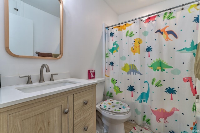 bathroom with toilet, curtained shower, and vanity