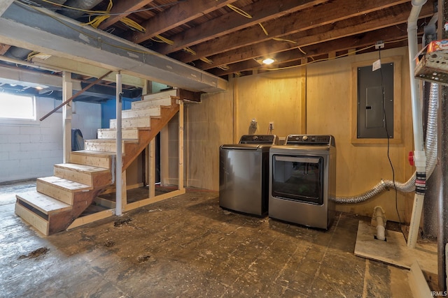 basement with stairway, independent washer and dryer, electric panel, and concrete block wall