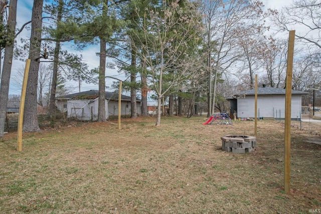 view of yard featuring an outdoor fire pit and fence