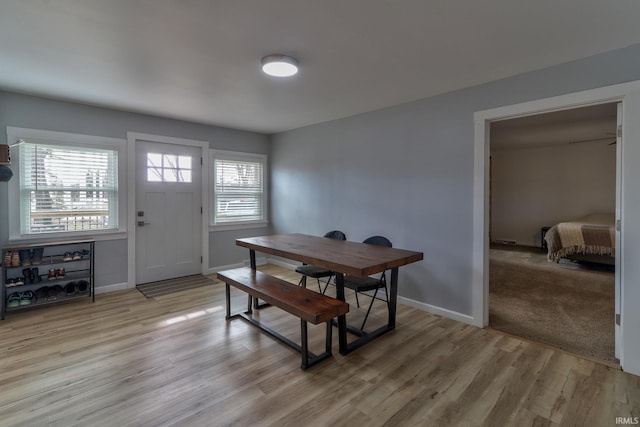 dining space featuring light wood-type flooring and baseboards