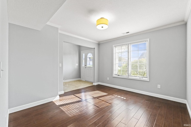 foyer entrance with ornamental molding, wood finished floors, and baseboards