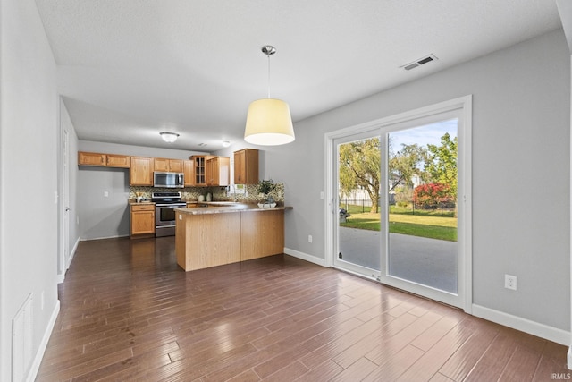 kitchen with stainless steel appliances, a peninsula, visible vents, decorative backsplash, and glass insert cabinets