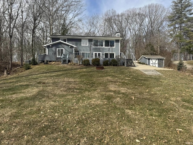 view of front facade with an outdoor structure, a detached garage, and a front lawn