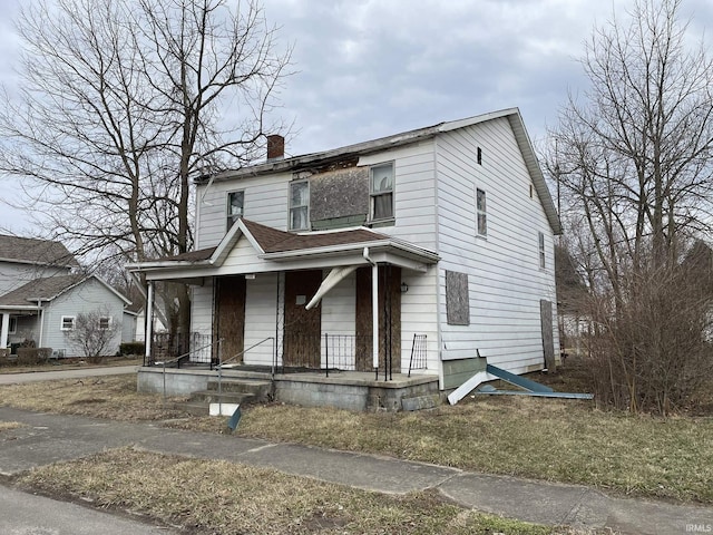 view of front of property with covered porch and a chimney