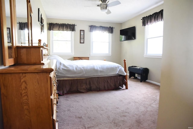 carpeted bedroom with ceiling fan and baseboards