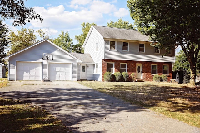 colonial-style house with driveway, brick siding, and an attached garage