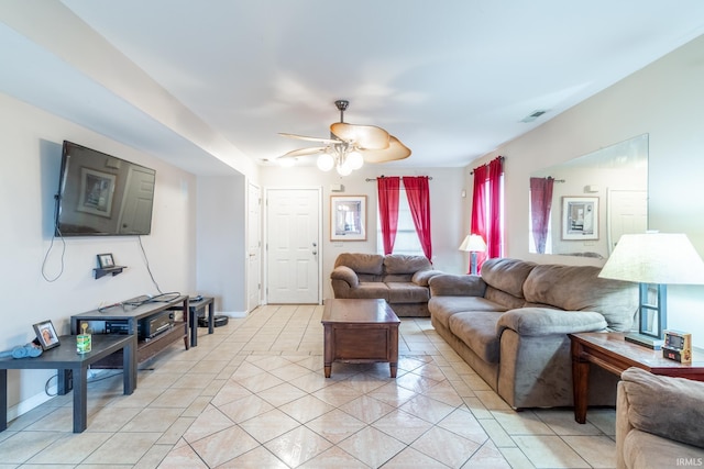 living area featuring a ceiling fan, visible vents, baseboards, and light tile patterned floors