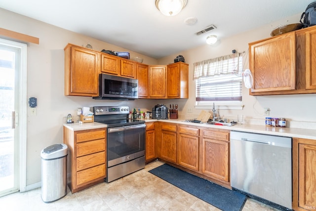 kitchen featuring visible vents, stainless steel appliances, a sink, and light countertops