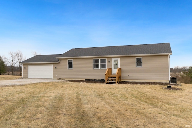 ranch-style home featuring central AC, a front lawn, an attached garage, and driveway