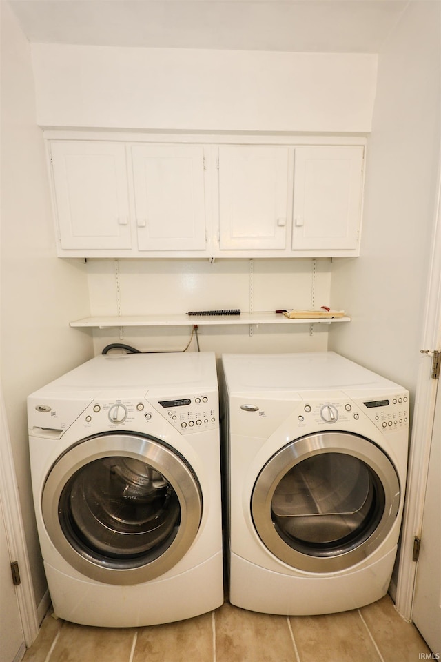 clothes washing area featuring cabinet space and washer and dryer