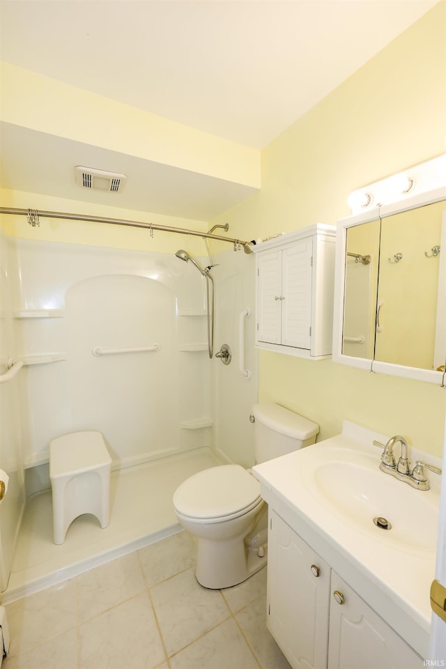 bathroom with toilet, vanity, walk in shower, and visible vents