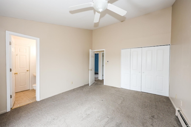 unfurnished bedroom with carpet floors, a baseboard radiator, a closet, lofted ceiling, and ensuite bath