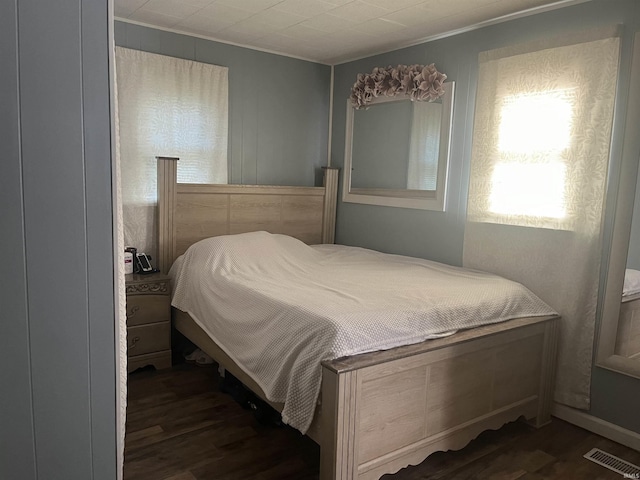 bedroom with dark wood-style floors and visible vents