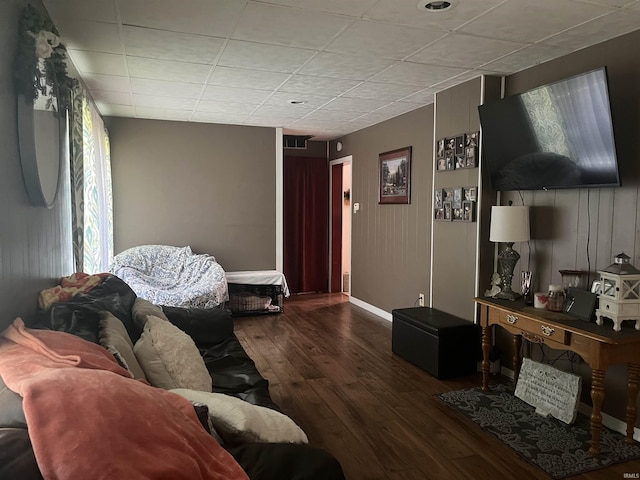 living area with wood finished floors, visible vents, and baseboards