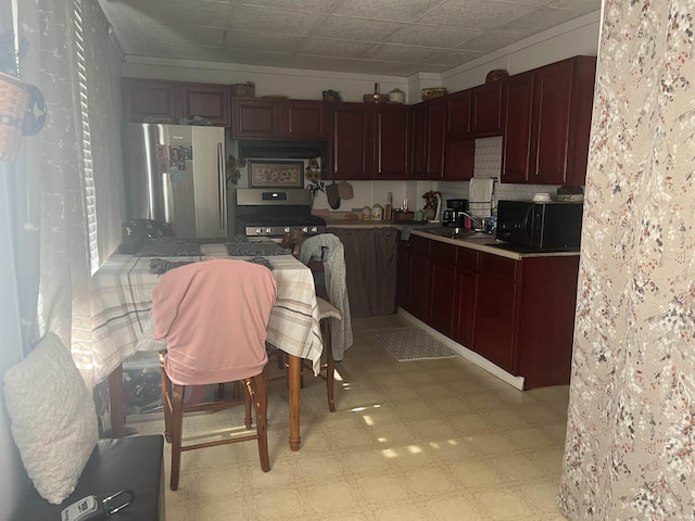 kitchen with stainless steel appliances, a sink, and light floors