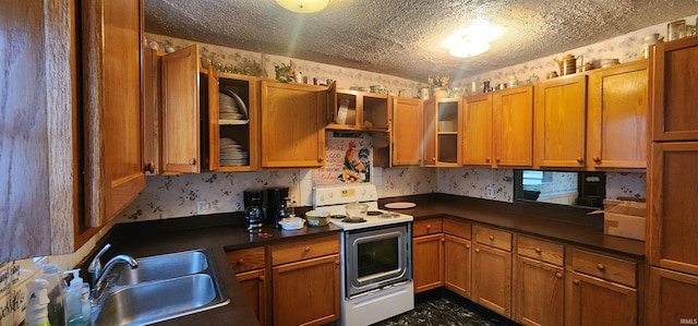 kitchen with white electric stove, a textured ceiling, a sink, and wallpapered walls