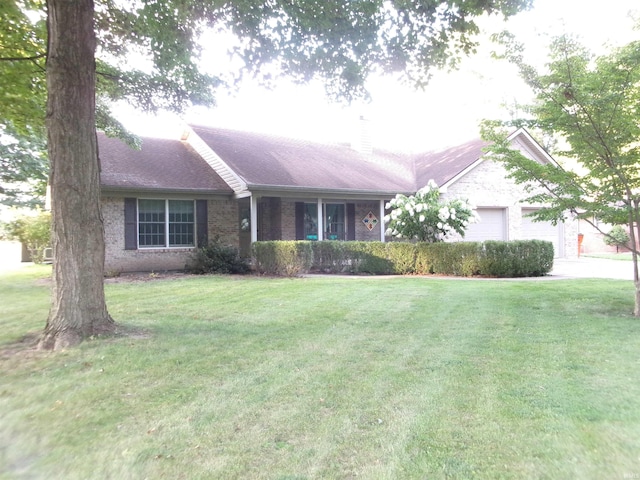 ranch-style home with a front lawn, roof with shingles, an attached garage, and brick siding