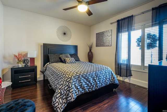 bedroom featuring a ceiling fan, visible vents, baseboards, and wood finished floors