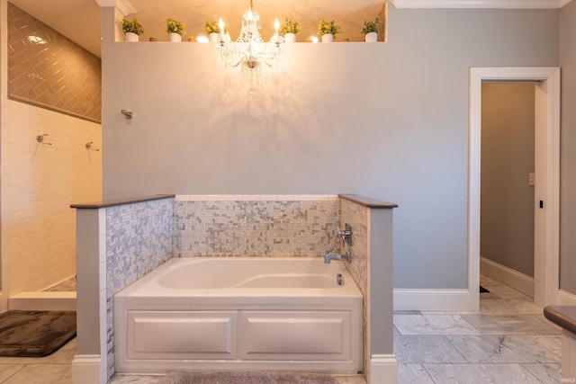 bathroom with marble finish floor, a notable chandelier, baseboards, and a bath