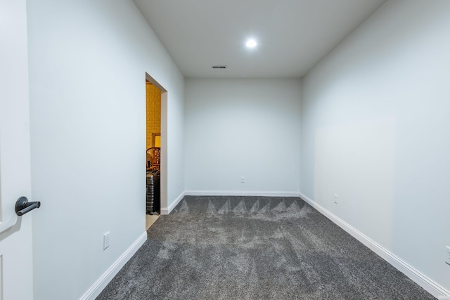 empty room with baseboards, visible vents, dark colored carpet, and recessed lighting