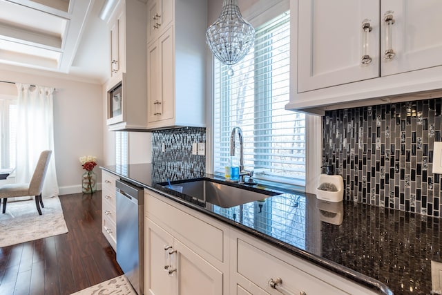 kitchen featuring dark wood-style floors, decorative backsplash, stainless steel dishwasher, a sink, and dark stone countertops