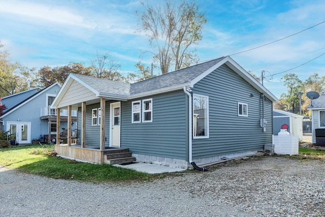 bungalow featuring a porch and roof with shingles