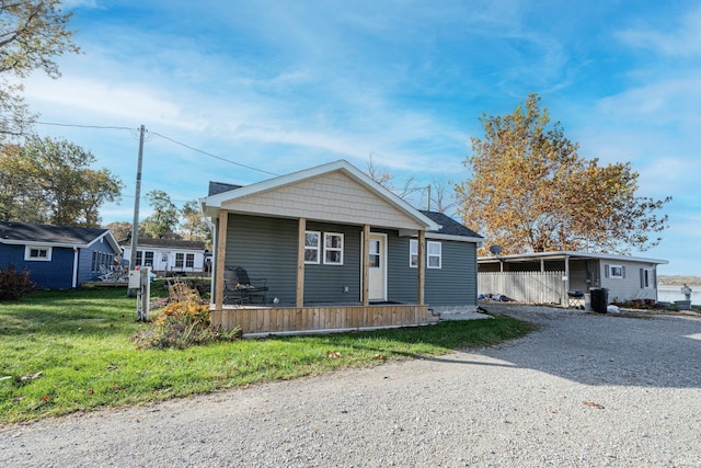 bungalow with driveway, covered porch, and a front yard