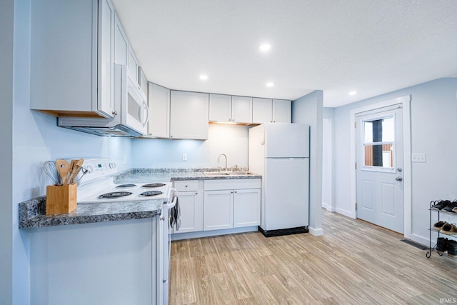 kitchen featuring recessed lighting, visible vents, light wood-style flooring, a sink, and white appliances