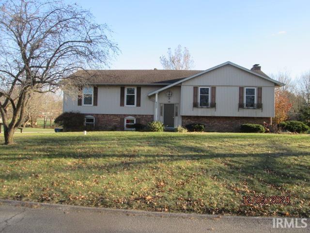 bi-level home featuring a front lawn and a chimney