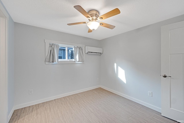 empty room with an AC wall unit, ceiling fan, and baseboards