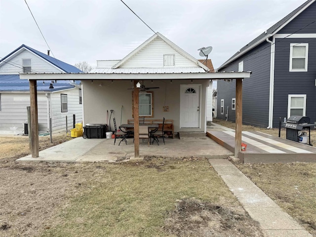 rear view of property with metal roof, a patio area, a ceiling fan, and stucco siding