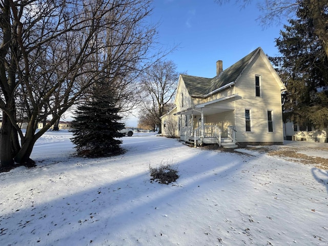 snow covered property with a chimney