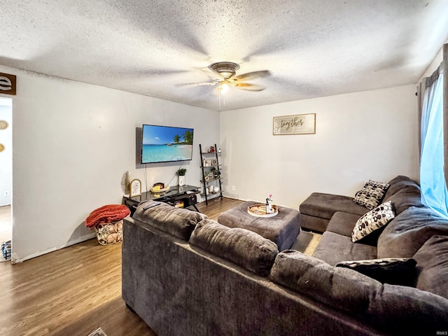 living area featuring a textured ceiling, wood finished floors, and a ceiling fan