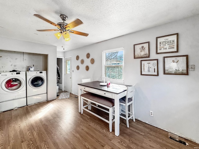 clothes washing area featuring ceiling fan, a textured ceiling, wood finished floors, washer and dryer, and laundry area