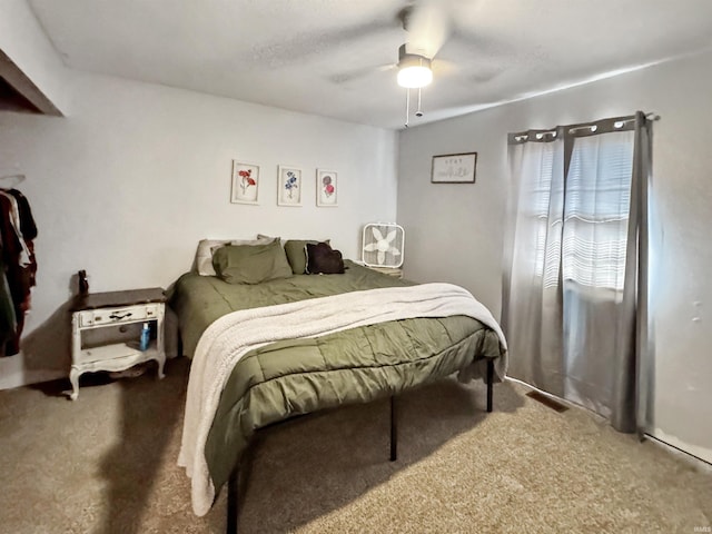 carpeted bedroom featuring ceiling fan and visible vents